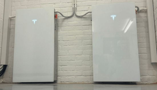 two Powerwall 3's installed against a white brick wall