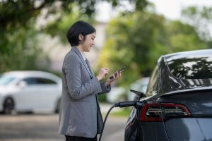 woman charging electric vehicle at EV Charging station