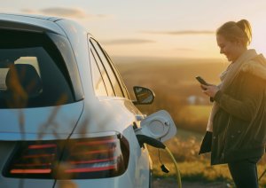 Woman charging EV in rural location